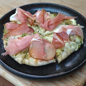 Pitapizza met roomkaas, pesto en zwarte woud ham - receptenwijzer.be