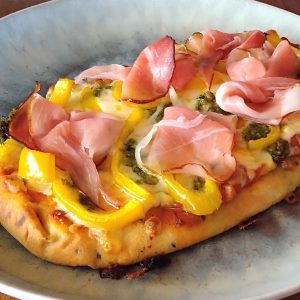 Naanpizza met pesto, gele paprika en zwarte woudham - receptenwijzer.be