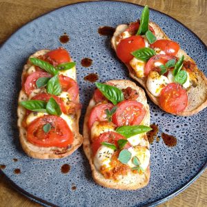 Toast met kerstomaatjes, mozzarella en verse kruiden - receptenwijzer.be